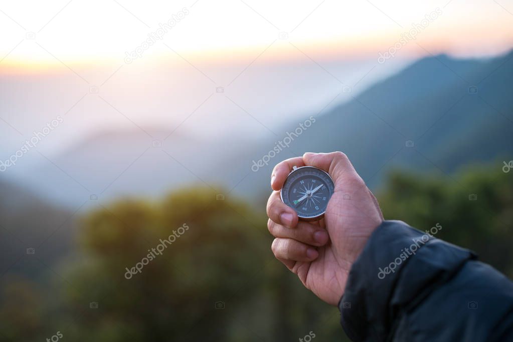 Travel concept,Male hand with compass on mountains background