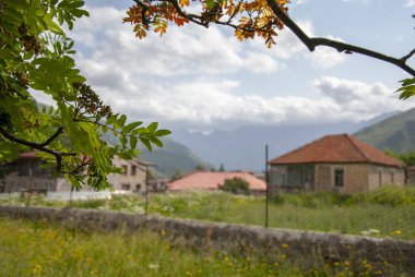 Yeşil çim ve mavi gökyüzü ile süslenmiş bir köy bakan bir güzel dağ manzarası