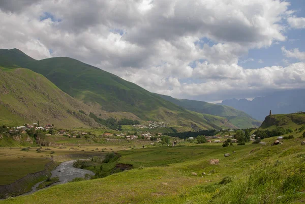 Yeşil çim ve mavi gökyüzü ile süslenmiş bir köy bakan bir güzel dağ manzarası