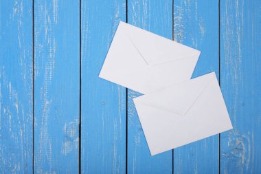 Postalama ve paketleme Servisi - mavi ahşap tahta arka plan üzerinde iki zarf.