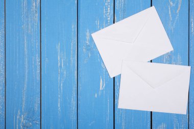 Postalama ve paketleme Servisi - mavi ahşap tahta arka plan üzerinde iki zarf.