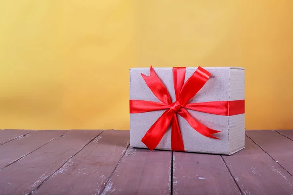 Brief Und Paketzustelldienst Päckchen Mit Roter Schleife Auf Braunem Holz — Stockfoto