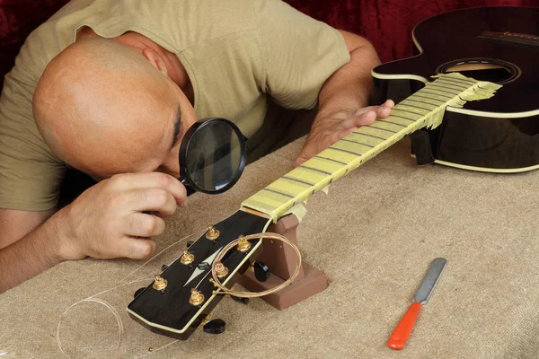 Musical instrument guitar repair and service - Worker control sharpen special tool bridge servo nut black acoustic guitar