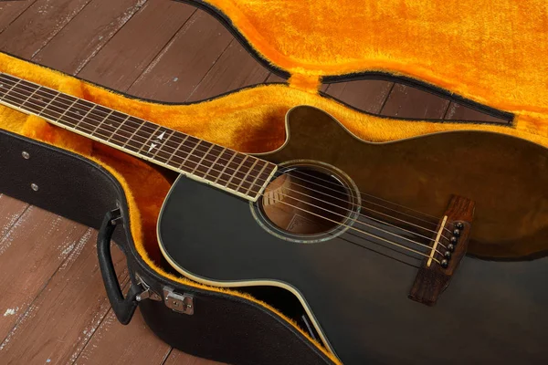 片段棕色剖面声学吉他在坚硬的情况下在木材背景 — 图库照片