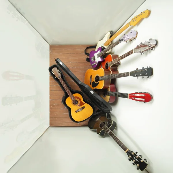 Musical instrument - lot of hard case, acoustic and electric guitars on a white and wood background.