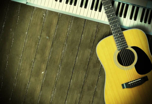 Müzik enstrümanı - Sloseup MIDI piyano 61 klavye ve ahşap arka planda akustik gitar