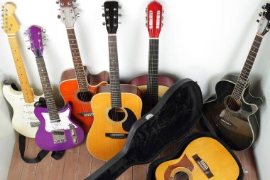 Musical instrument - lot of hard case, acoustic guitars on a white and wood background. clipart
