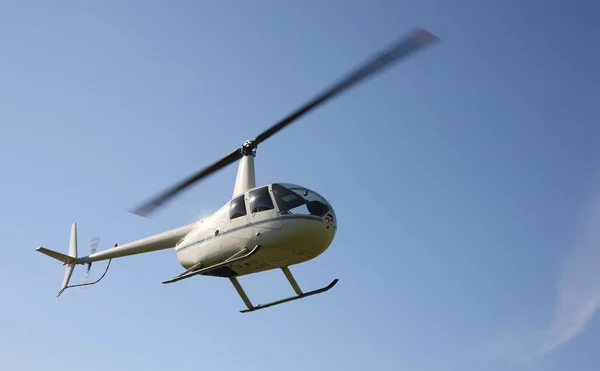 The aircraft - White small helicopter makes flight low height — Stock Photo, Image