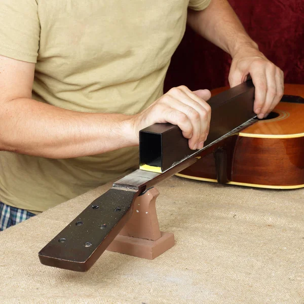 Reparação e serviço de guitarra - Trabalhador grinds nat guitarra pescoço trastes — Fotografia de Stock