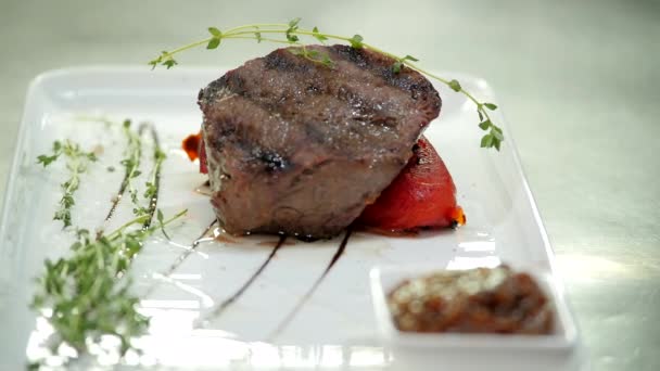 Una ligera ramita de tomillo complementa el plato de carne — Vídeos de Stock