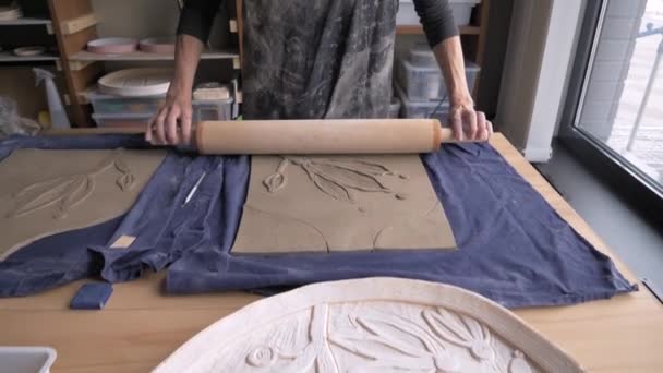 Woman working with clay, roll out clay with a rolling pin dolly shot — Stock Video