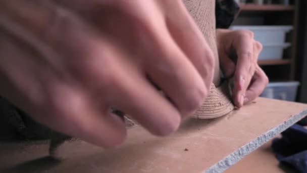 Ceramist lays out a pattern on the future vase for flowers, dolly shot — Stock Video