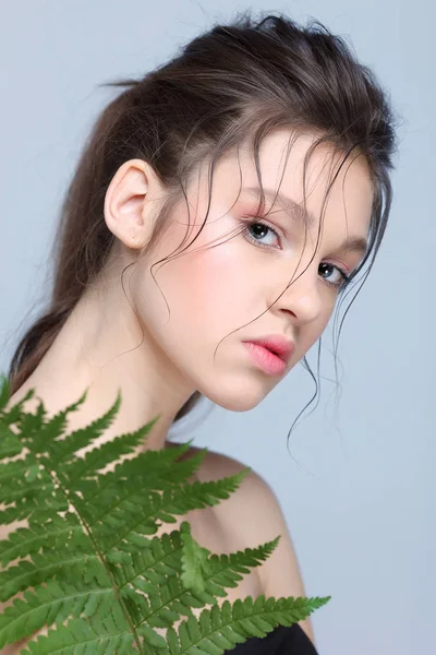 Beautiful  girl with fern leaf, isolated on a light - grey  background, emotions, cosmetics Royalty Free Stock Photos