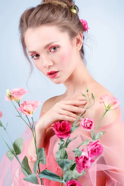 Menina bonita, isolado em um fundo azul com flores variadas, emoções, cosméticos — Fotografia de Stock