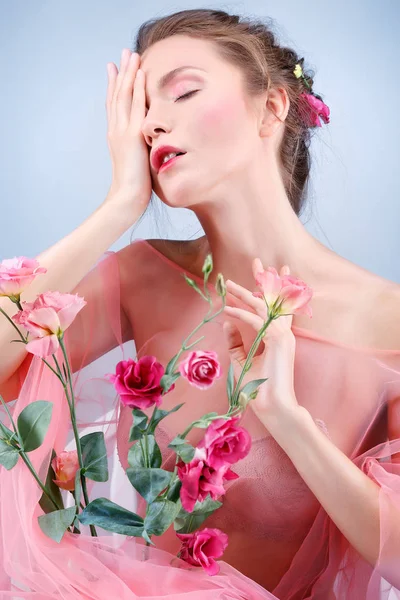 Krásná dívka, izolovaná na modrém pozadí s pestrobarevnou květenkou, emocemi, kosmetikou — Stock fotografie