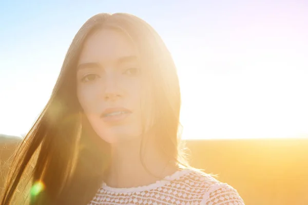 Retrato de uma mulher atraente sobre o campo de trigo dourado no dia de verão — Fotografia de Stock