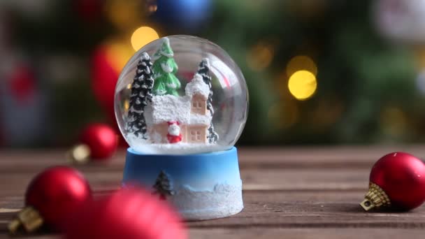 Navidad bola de nieve copo de nieve con nevadas en el fondo del árbol de Navidad — Vídeos de Stock