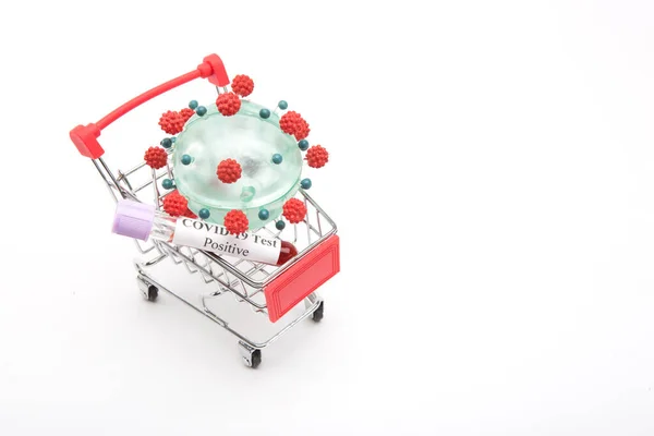 Coronavirus modell egy bevásárlókocsiban, fehér alapon — Stock Fotó