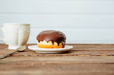 Tahta tabakta Danimarka pastası ve masada sıcak kahve.