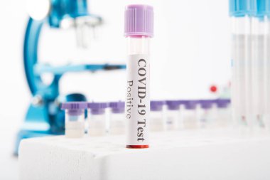 Beyaz arka planda COVID-19 testi pozitif çıkan test tüpü. Virüs Salgını Koruma Konsepti