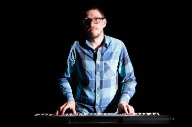 Klavyede çalan müzisyen karanlıkta elektrikli piyano. Müzisyen konsepti.