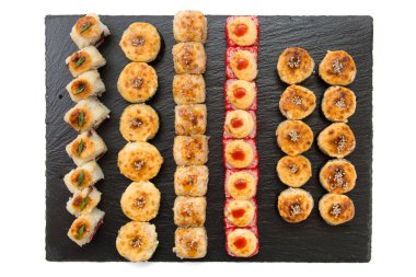 Kızarmış suşi, balık ve pirinçli siyah taş levha..