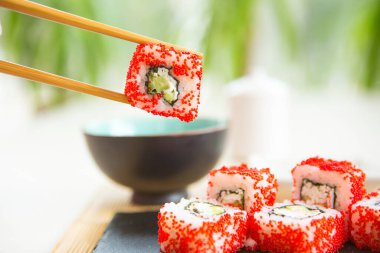 Somon balığı kara tahta yüzeyde yuvarlanır. Japon yemeği..