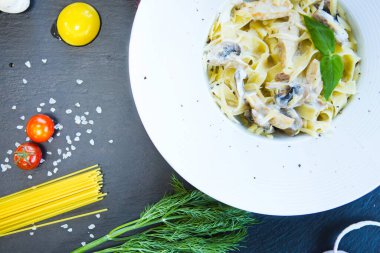 Siyah arka planda mantarlı makarna..