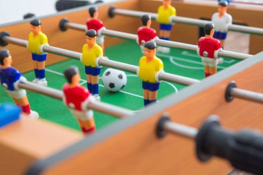 Sarı ve kırmızı oyuncuların ve beyaz kalecinin oynadığı masa futbolu. Masa futbolu oyunu.