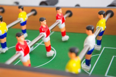 Sarı ve kırmızı oyuncuların ve beyaz kalecinin oynadığı masa futbolu. Masa futbolu oyunu.