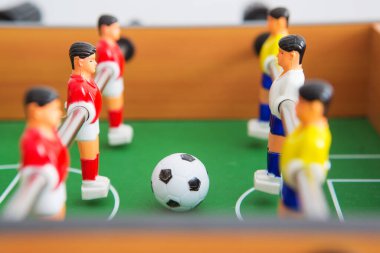 Sarı ve kırmızı oyuncuların ve beyaz kalecinin oynadığı masa futbolu. Masa futbolu oyunu.
