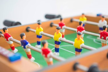 Sarı ve kırmızı oyuncuların ve beyaz kalecinin oynadığı masa futbolu. Masa futbolu oyunu.
