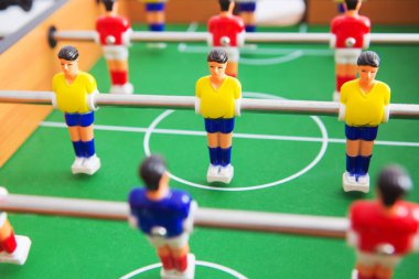 Sarı ve kırmızı oyuncuların ve beyaz kalecinin oynadığı masa futbolu. Masa futbolu oyunu.