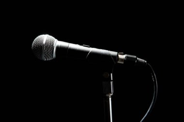 Siyah modern mikrofon, siyah siyah arka plan. Işıkla vurgulanmış şekiller. Müzik ve konser konsepti.
