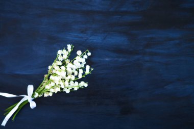 Narin bir kokusu olan harika kokulu beyaz çiçekler. Vadi çiçekleri siyah ahşap masa üzerinde Kopya alanı.