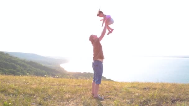 Papà e sua figlia si stanno godendo il tramonto sulla riva del lago di montagna. — Video Stock