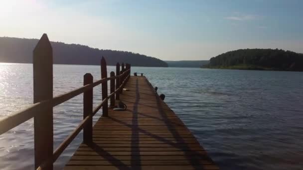 First person video. Jump from a pier into the sea or a lake in the mountains and take off up into the sky. Aerial video — Stock Video