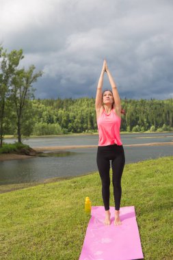 Parktaki doğadaki kız yogayla meşgul. Sağlıklı yaşam tarzı.