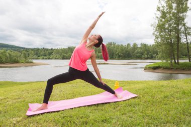 Parktaki doğadaki kız yogayla meşgul. Sağlıklı yaşam tarzı.