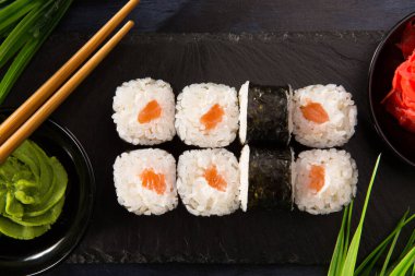 Siyah arka planda wasabi ve zencefilli suşi ruloları. Japon Doğu mutfağı.