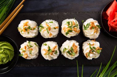 Siyah arka planda wasabi ve zencefilli suşi ruloları. Japon Doğu mutfağı.