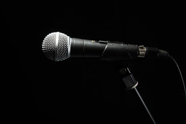 Zwarte klassieke microfoon op zwarte donkere achtergrond. Muziek en concertconcept. — Stockfoto