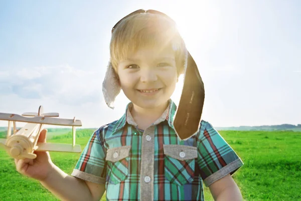 Happy child dreams of traveling and playing with an airplane pilot aviator in outdoor in the summer. Start traveling from childhood even in imagination — Stock Photo, Image