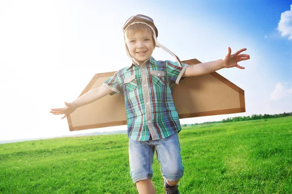 Start traveling from childhood even in imagination. Child playing pilot aviator in the grass field — Stock Photo, Image