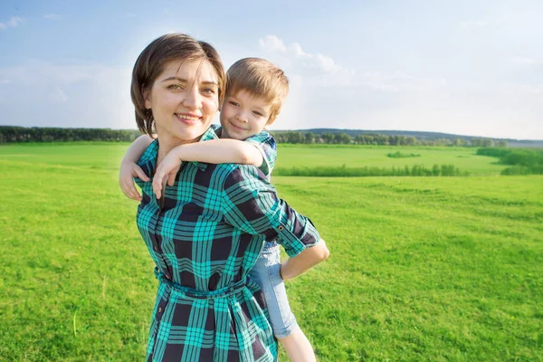 Mother and son having fun on green field — Stock Photo, Image