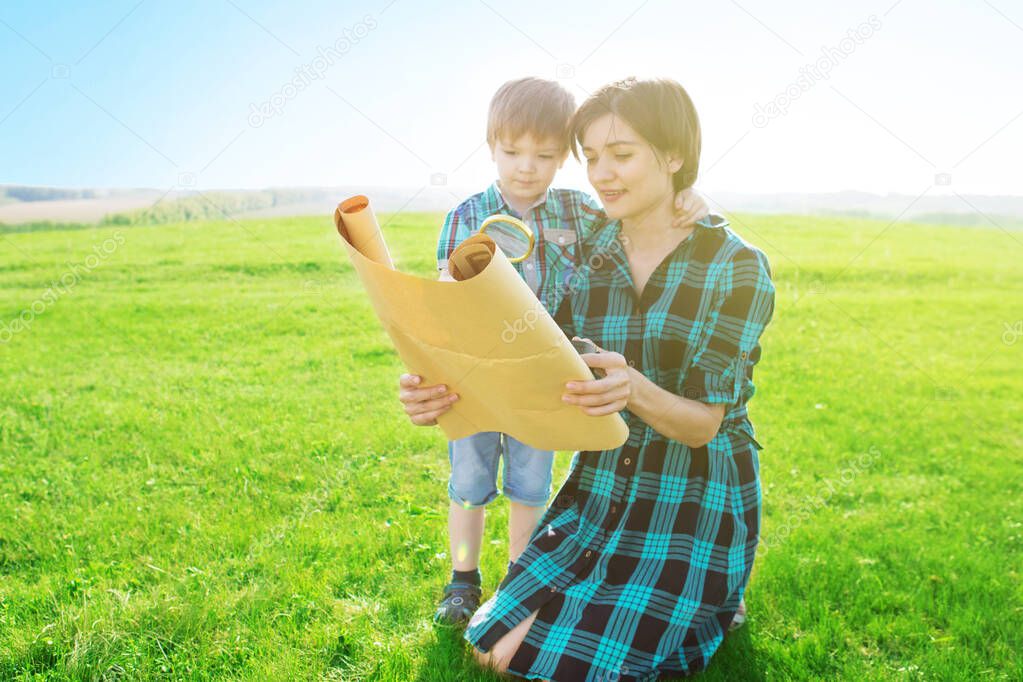 This world without borders. Go to new adventures and discoveries. A beautiful young mother with her son looks at a map of the world and decide where to go on a trip