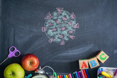 Tahtanın arka planında okul malzemeleri var. Okula geri dön.
