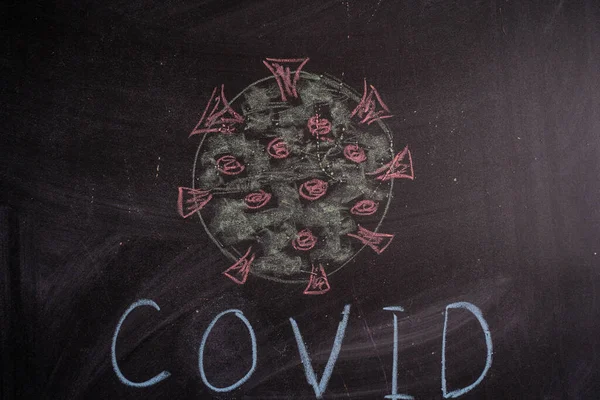 Krijttekening van een virus COVID-19 op de achtergrond van schoolbord. Terug naar school — Stockfoto