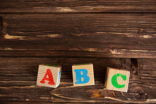 Cubos com letras ABC na mesa de madeira rústica — Fotografia de Stock