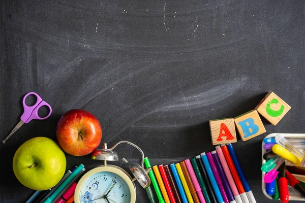 Tahtanın arka planında okul malzemeleri var. Okula geri dön.